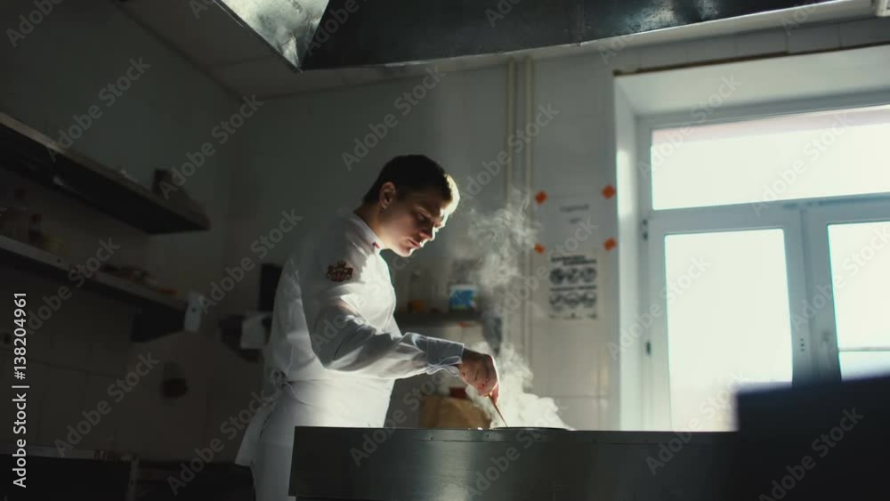 Professional chef man prepare gravy sauce with spices on oven at restaurant kitchen Professional chef man prepare gravy sauce with spices on oven at restaurant kitchen