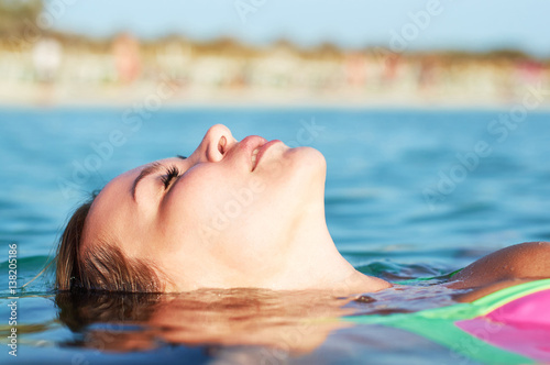 Young girl lying on sea water.