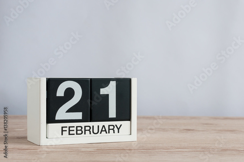 February 21st. Day 21 of month, black and white calendar on wooden desk background. Winter time. Empty space for text