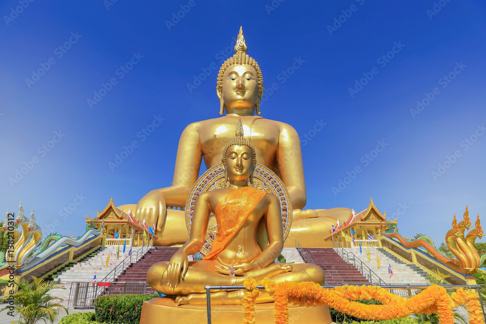biggest golden buddha statues in wat muang public temple at angthong province, thailand on blue sky background biggest golden buddha statues in wat muang public temple at angthong province, thailand on blue sky background