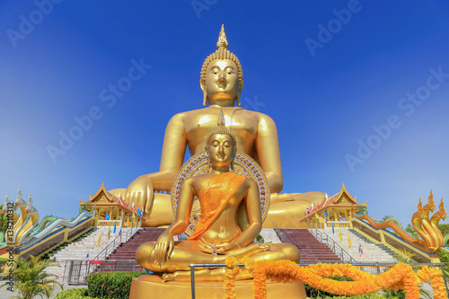    biggest golden buddha statues in wat muang public temple at angthong province  thailand on blue sky background