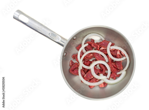 Top view of sliced steak with onions in a skillet isolated on a white background.