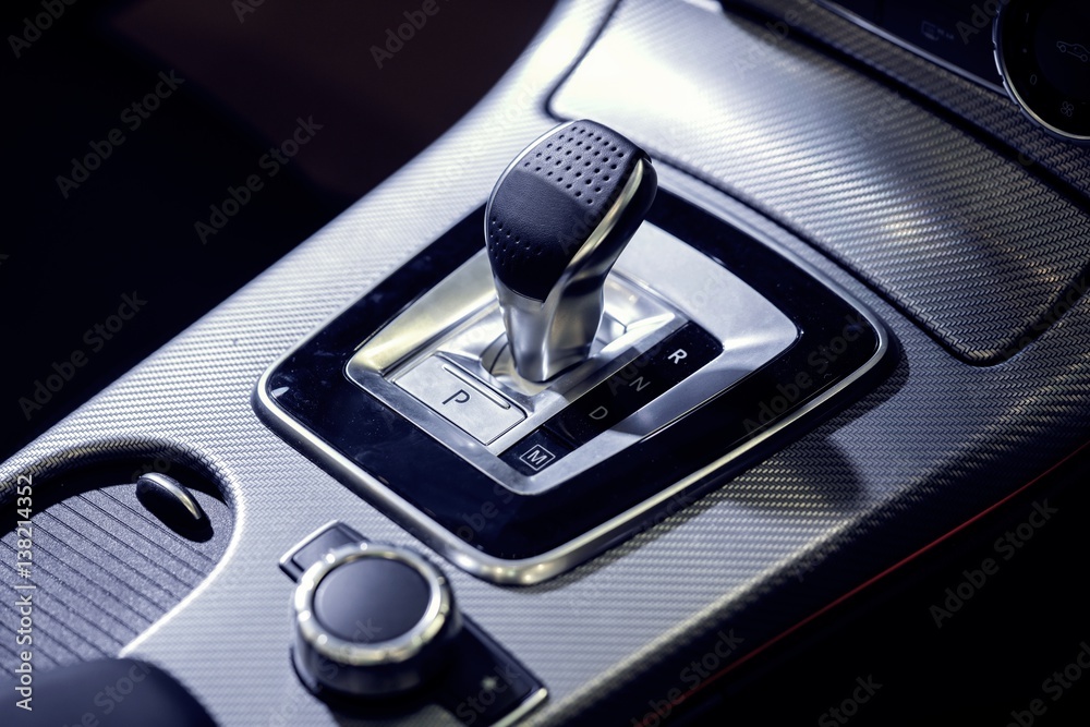 Automatic gear stick with manual selection option.
Detail on a automatic gear shifter in a luxury car.