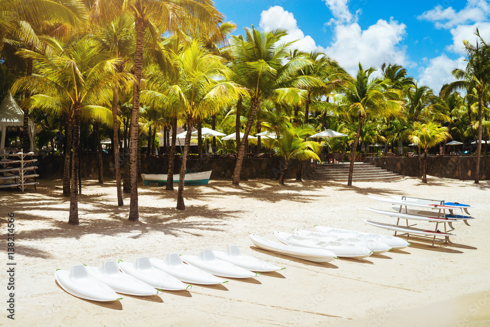 Fototapeta premium Tropical island view. Shell, boats and surfboats on sand.