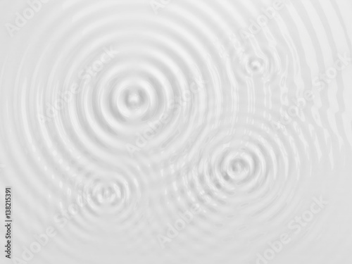 Ripples on a white liquid surface.