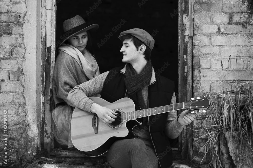 Love happy couple on a date on the ruins of an old building with a guitar