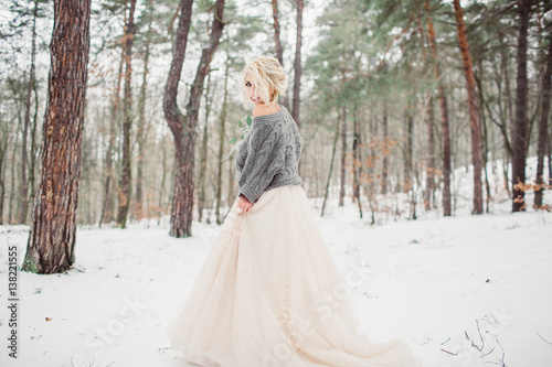 Beautiful stylish smiling bride posing in the winter park