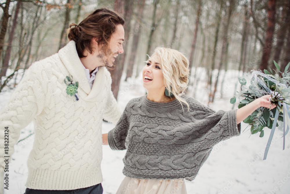 Smiling romantic couple posing in the winter forest