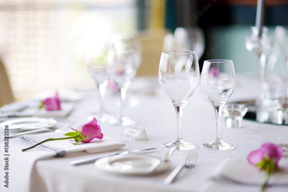 Beautiful table setting with crockery and flowers for a party, wedding reception or other festive event Beautiful table setting with crockery and flowers for a party, wedding reception or other festive event