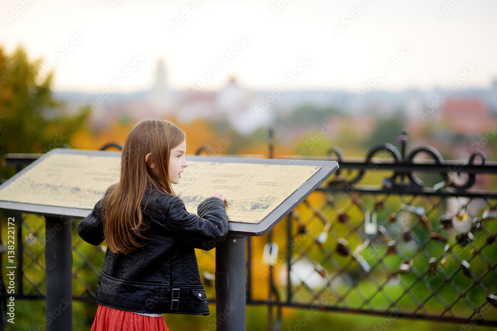 Naklejka premium Cute little girl enjoying a view of Vilnius city on autumn day