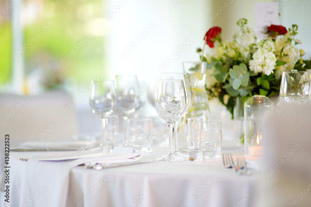 Beautiful table setting with crockery and flowers for a party, wedding reception or other festive event Beautiful table setting with crockery and flowers for a party, wedding reception or other festive event
