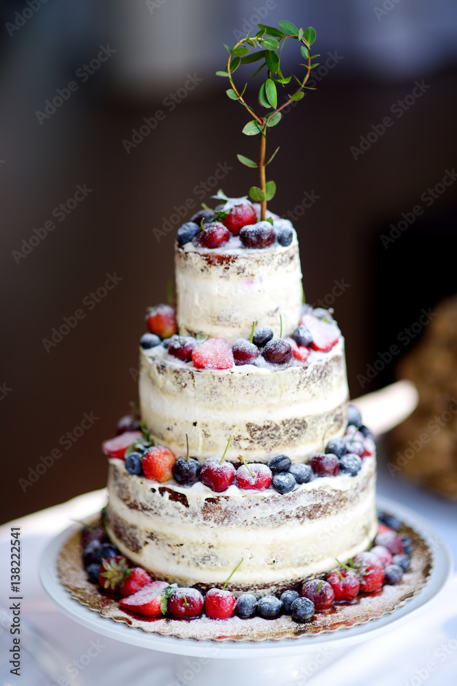 Delicious chocolate wedding cake decorated with fruits and berries Delicious chocolate wedding cake decorated with fruits and berries