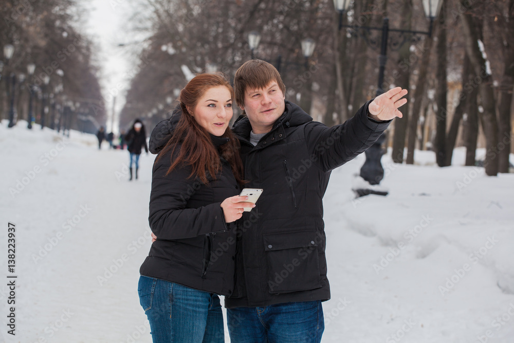 man and woman on a winter outing to the gadget in his hands