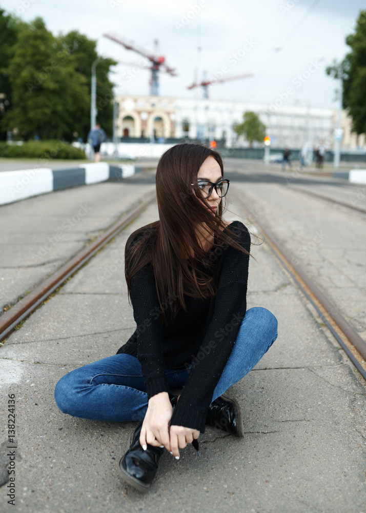 Fototapeta premium Young girl in glasses walking in summer in the city. The concept of lifestyle and fashion