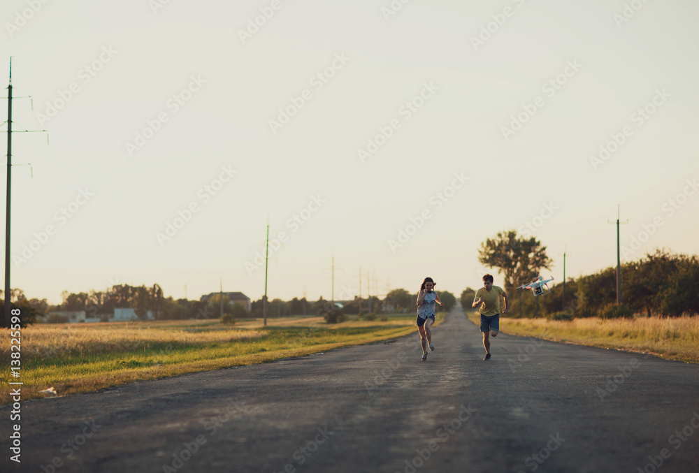 young woman and her man  running on the broad road