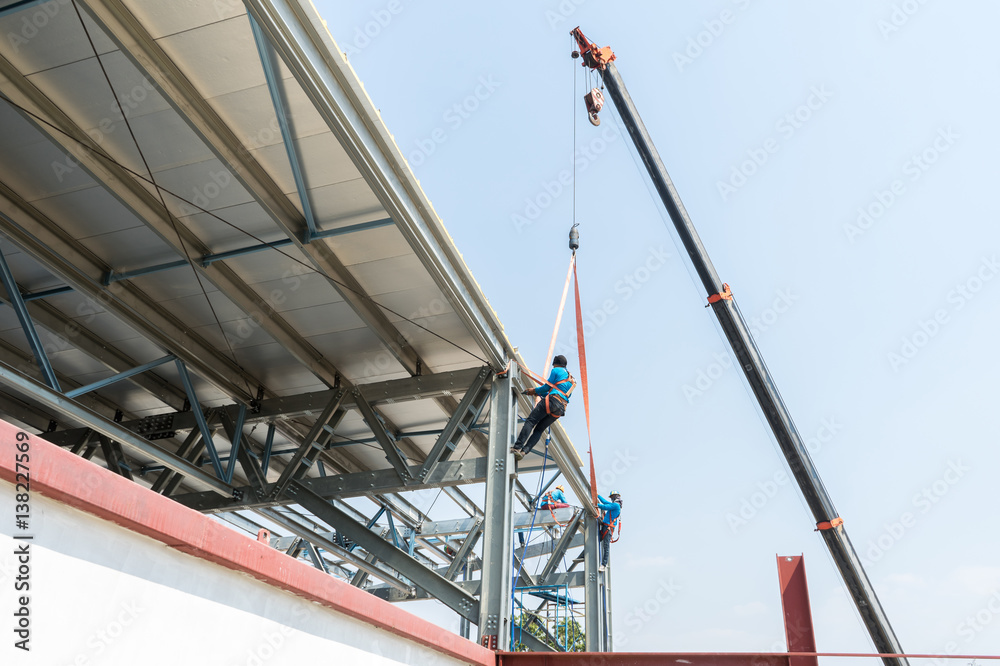 Workers working on at high .installation steel roof Workers working on at high .installation steel roof
