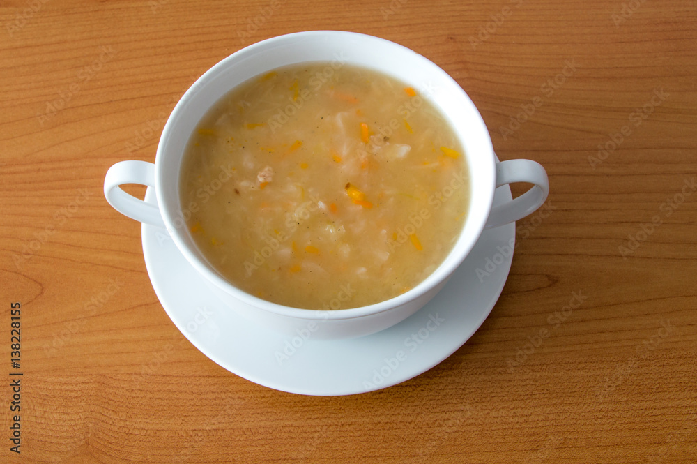 Polish cabbage soup in a white bowl on wooden background. Soup knows in Poland as Kapusniak. Polish cabbage soup in a white bowl on wooden background. Soup knows in Poland as Kapusniak.