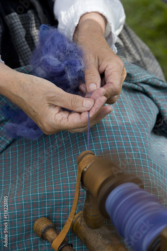 Spinning yarn at spinning wheel. Wool.  photo