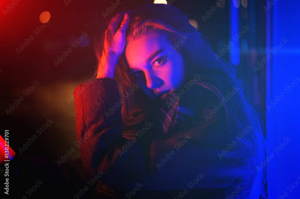 Sexy young beauty woman posing over night city dramatic red and blue neon background Sexy young beauty woman posing over night city dramatic red and blue neon background