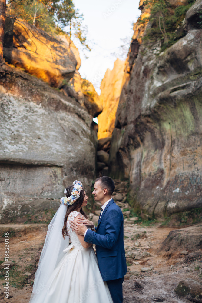 The charming brides embracing near stones The charming brides embracing near stones