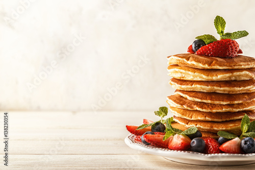 Homemade pancakes with berries and fruit on a white background. photo