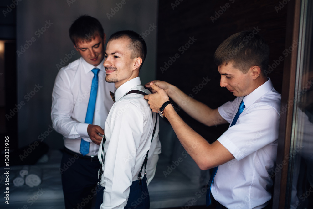 The groom with groomsmen wear suspenders