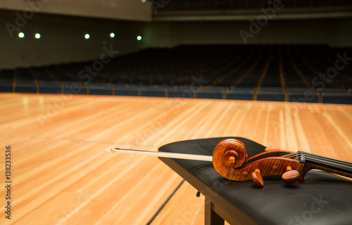 a pegbox of cello with a bow in empty concert hall photo