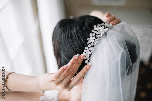 beautiful tiara with diamonds and veil on head of the bride
