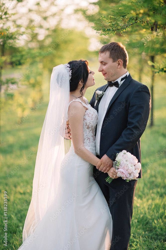 beautiful and young bride and groom standing outdoors beautiful and young bride and groom standing outdoors