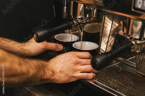 Barista prepares cappuccino in his coffeeshop close up