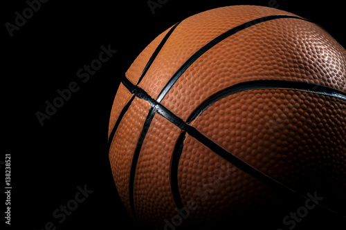 Sports, athletics and basketball concept with hard spotlight on orange ball against a dark background with copy space © Victor Moussa