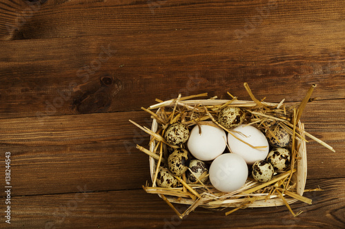 Chicken and quail eggs on the wooden table. Easter background