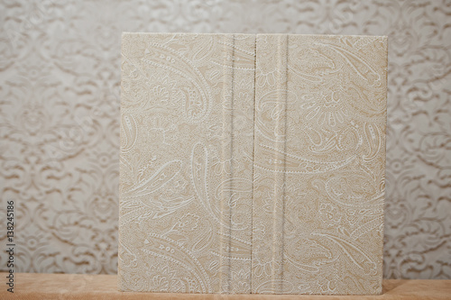 Elegant wedding album and photo book from beige material.