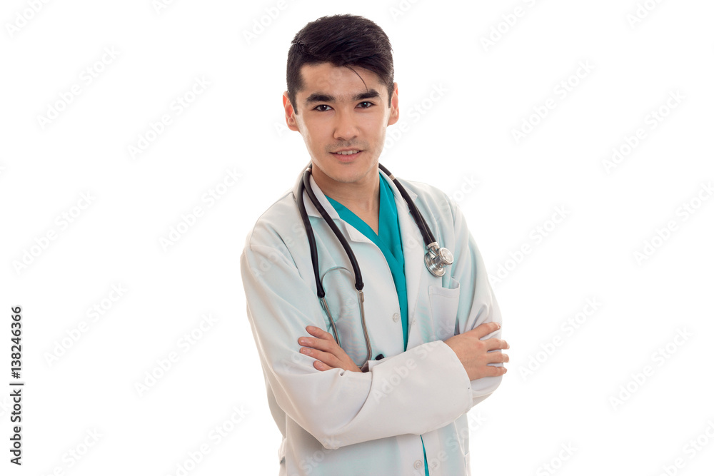 young handsome brunette male doctor in uniform with stethoscope posing and looking at the camera isolated on white background young handsome brunette male doctor in uniform with stethoscope posing and looking at the camera isolated on white background