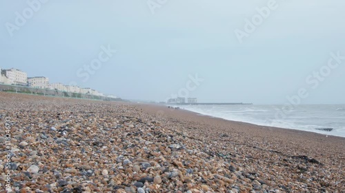 Static view of the beautiful pebble beach in Brighton, Sussex, UK, just east of the pier. Looking east you see the houses along Madeira Drive / Marine Parade to the left. December 24 2016. photo