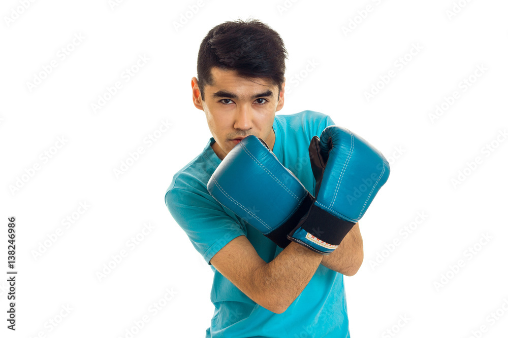 Handsome young sports man in blue gloves and uniform practicing boxing isolated on white background Handsome young sports man in blue gloves and uniform practicing boxing isolated on white background
