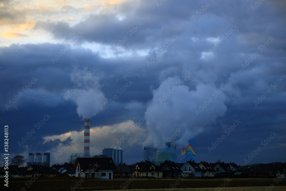 Dymiące kominy elektrowni węglowej w Opolu wieczorem, osiedle domków jednorodzinnych.