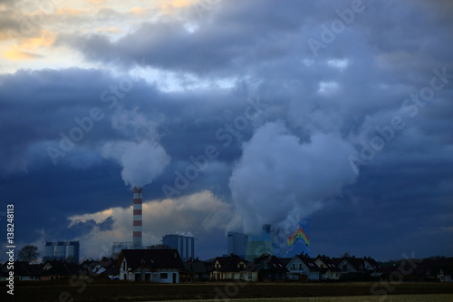Dymiące kominy elektrowni węglowej w Opolu wieczorem, osiedle domków jednorodzinnych.