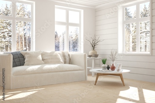 White room with sofa and winter landscape in window. Scandinavian interior design © AntonSh