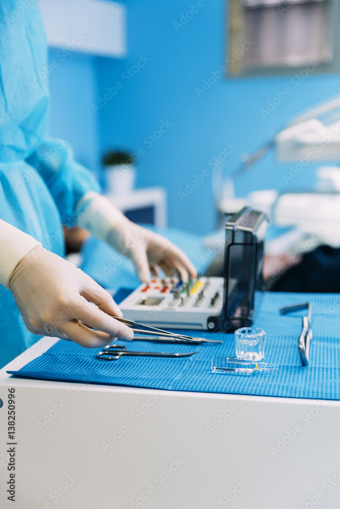 Detail of hand holding dental tools in dental clinic.