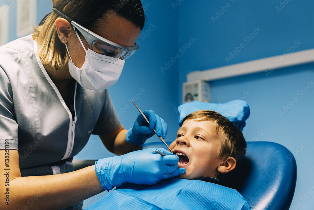 Fototapeta premium Dentists with a patient during a dental intervention to boy.
