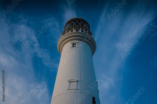 Flamborough lighthouse against clouded sky.