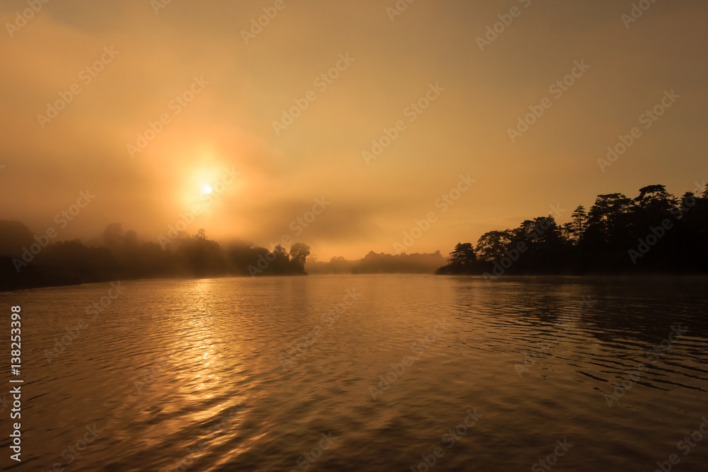 Misty sunrise over a jungle river