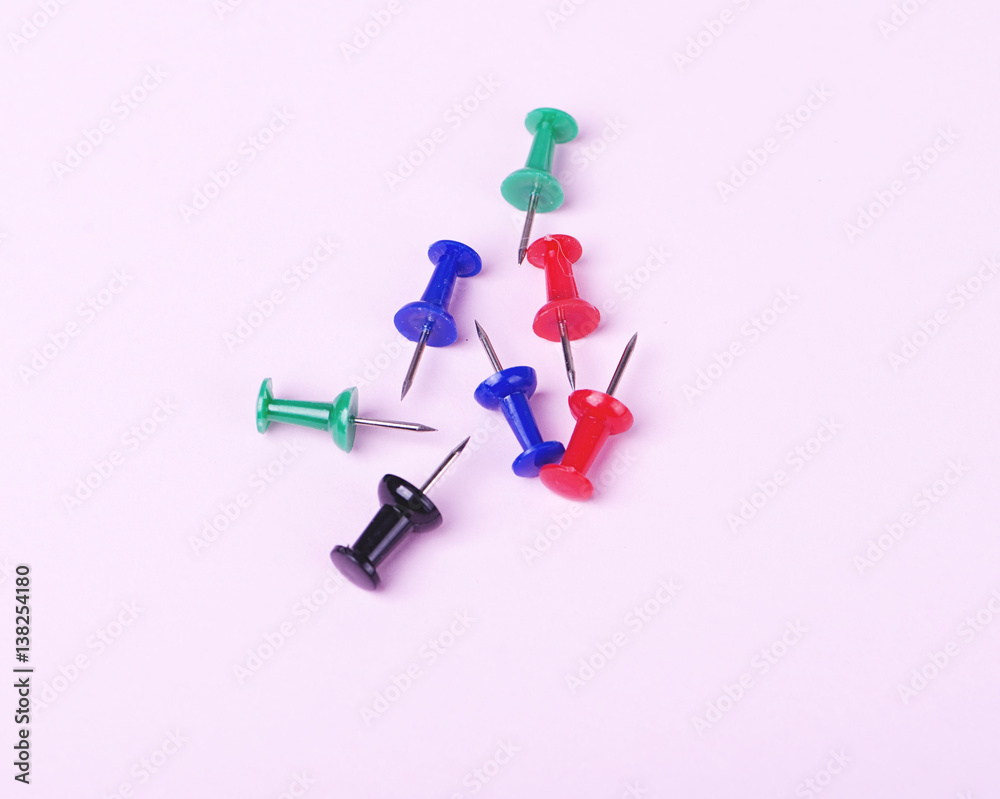 Colorful pushpin on pink background.
