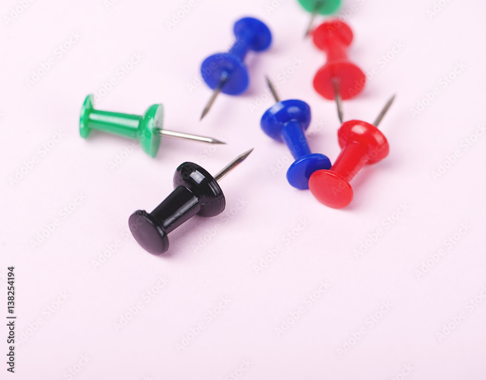 Close-up of colorful push pins on pink background. Close-up of colorful push pins on pink background.