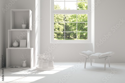 White room with chair and green landscape in window. Scandinavian interior design