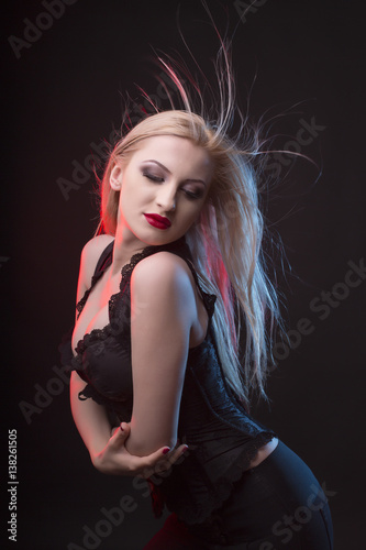 Stunning woman in corset with long blonde hair in motion