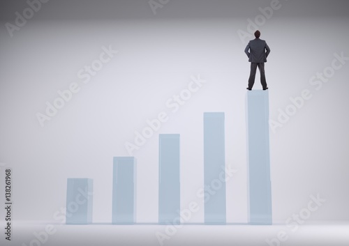 Businessman standing on a graph against a grey background 