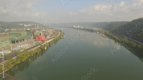 Aerial Shot Flying Down Ohio River to Reveal Factory and Steel Bridge outside St photo