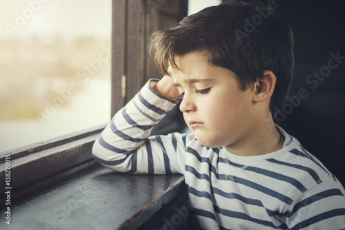 Schilderij op canvas niño triste al lado de una ventana